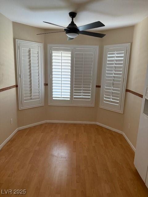 spare room featuring light wood-style flooring, baseboards, and ceiling fan