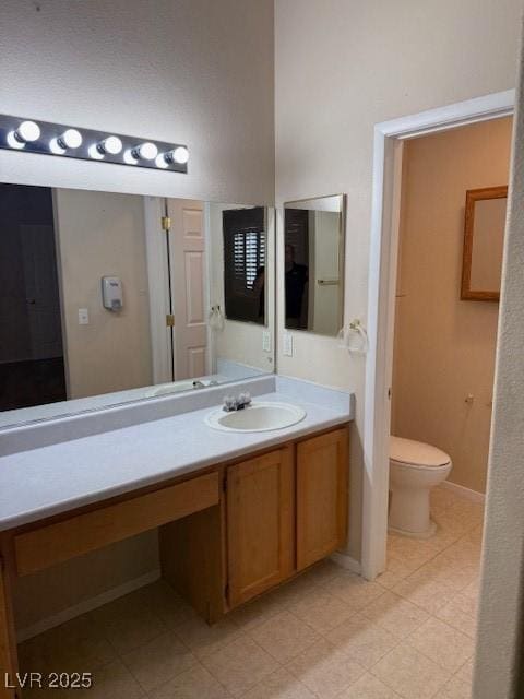 bathroom with vanity, toilet, and baseboards