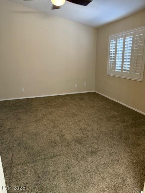 unfurnished room featuring baseboards, ceiling fan, and dark carpet