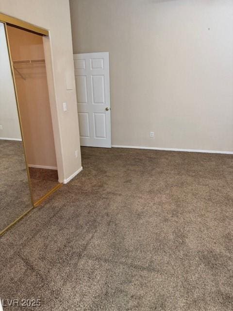 unfurnished bedroom with carpet, a closet, and baseboards