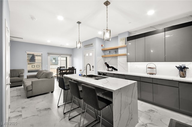 kitchen featuring tasteful backsplash, a sink, gray cabinetry, modern cabinets, and open shelves