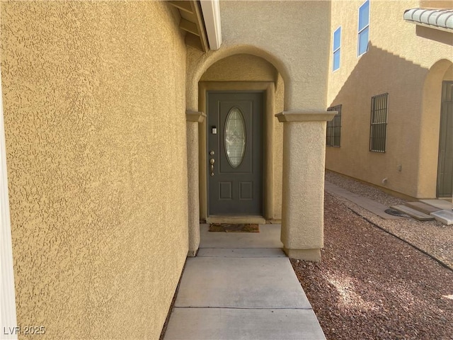 doorway to property featuring stucco siding