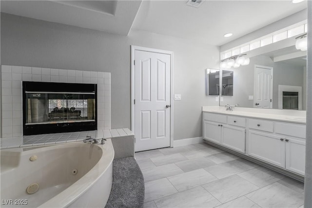 full bathroom featuring visible vents, marble finish floor, a jetted tub, baseboards, and vanity