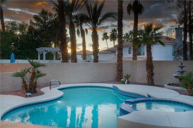 view of swimming pool featuring a fenced backyard and a pool with connected hot tub