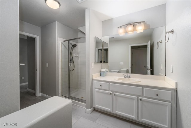 full bathroom with vanity, baseboards, and a stall shower