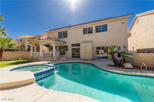 view of swimming pool featuring a patio area, fence, and a pool with connected hot tub