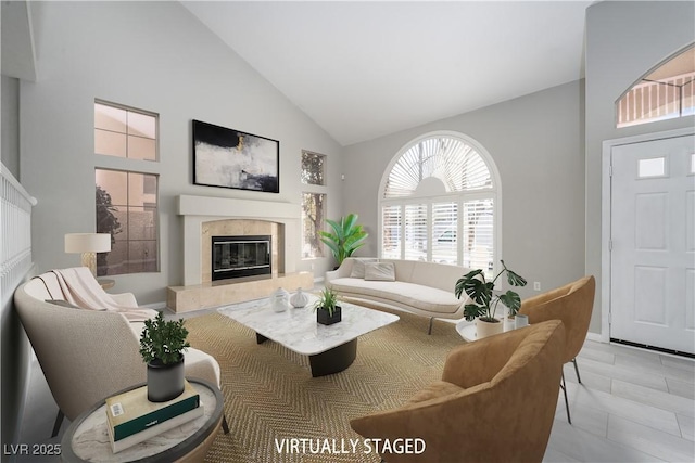 living room with a fireplace and high vaulted ceiling