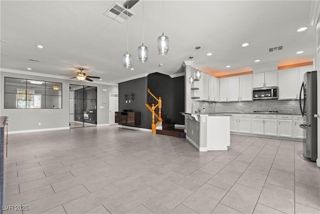 kitchen with visible vents, stainless steel appliances, crown molding, and open floor plan