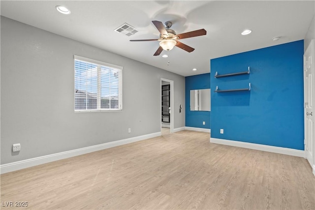 empty room featuring visible vents, baseboards, light wood-style floors, and ceiling fan