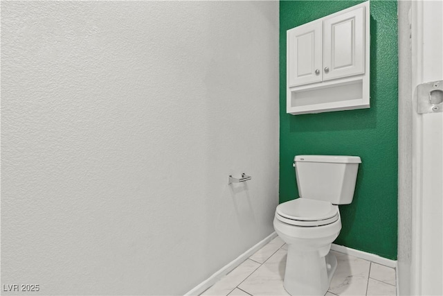 bathroom featuring marble finish floor, toilet, and baseboards