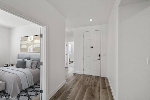 hallway featuring recessed lighting, baseboards, and wood finished floors