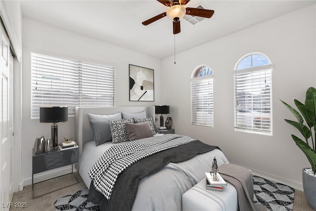 carpeted bedroom with baseboards, a closet, and ceiling fan