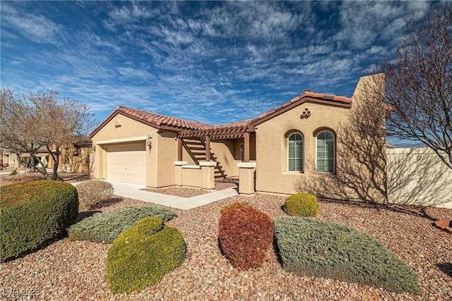 mediterranean / spanish-style home with concrete driveway, a tiled roof, an attached garage, and stucco siding