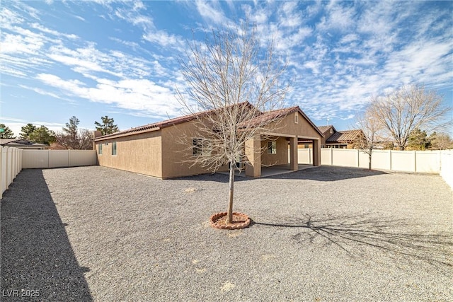 rear view of property with a patio, a fenced backyard, and stucco siding