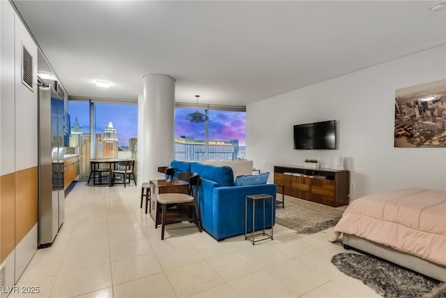 living room with light tile patterned floors, visible vents, and floor to ceiling windows