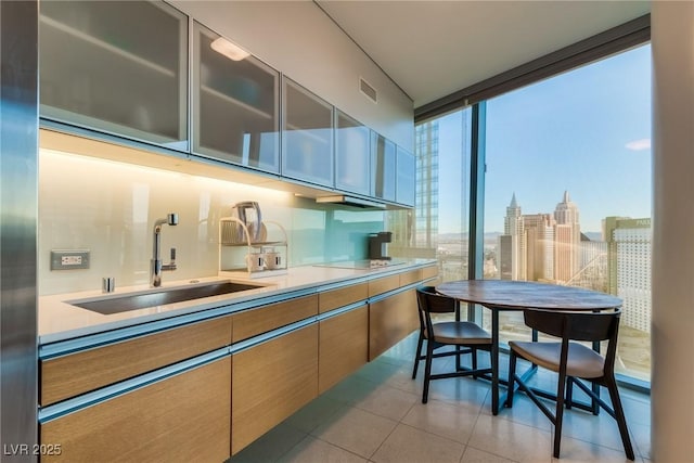 kitchen with a sink, visible vents, light countertops, and light tile patterned floors