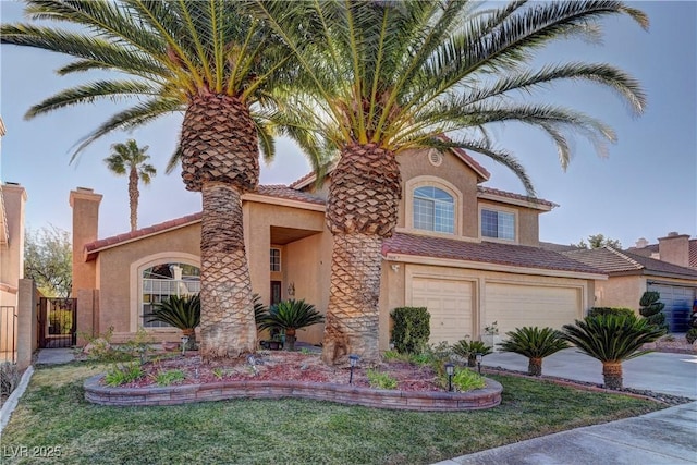 mediterranean / spanish house featuring stucco siding, driveway, a chimney, and an attached garage