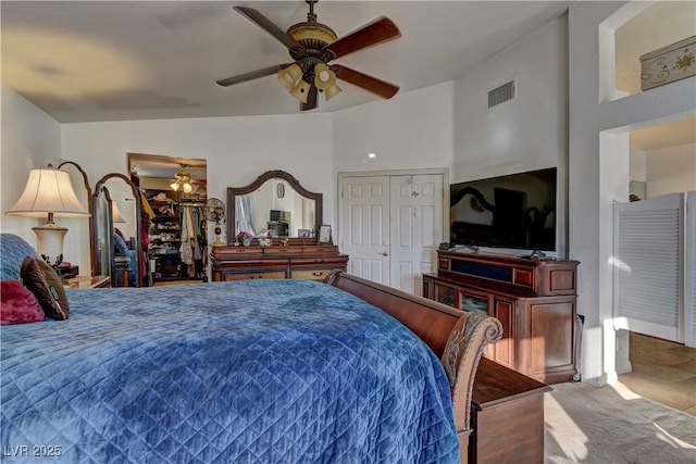 carpeted bedroom with vaulted ceiling, a ceiling fan, visible vents, and a closet