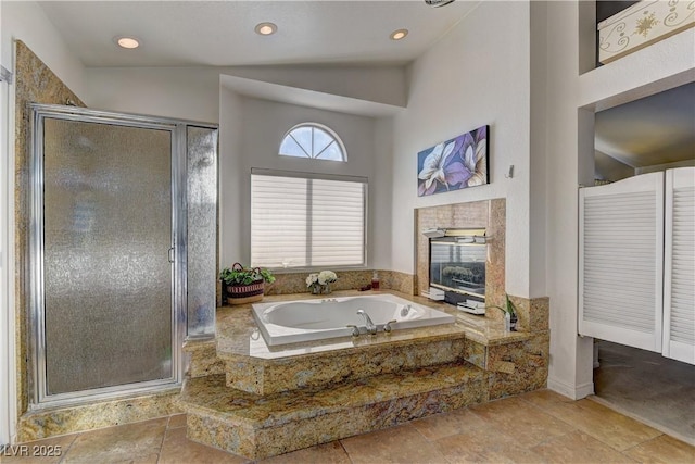 bathroom featuring a shower stall, a garden tub, a fireplace, and recessed lighting