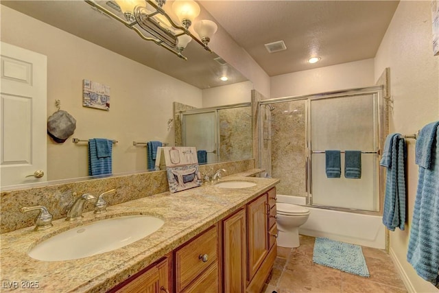 bathroom featuring bath / shower combo with glass door, toilet, double vanity, tile patterned floors, and a sink