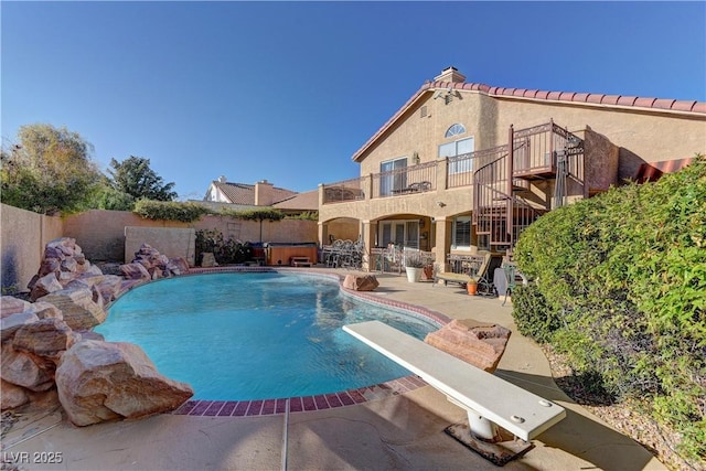 view of pool featuring a fenced backyard, a fenced in pool, a patio, and a diving board