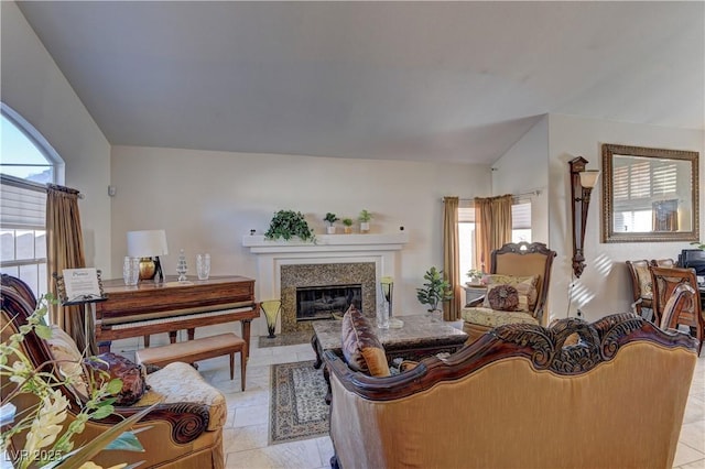 living room with lofted ceiling, light tile patterned floors, and a premium fireplace