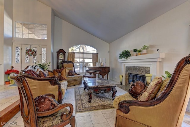 living area with light tile patterned floors, a premium fireplace, and high vaulted ceiling