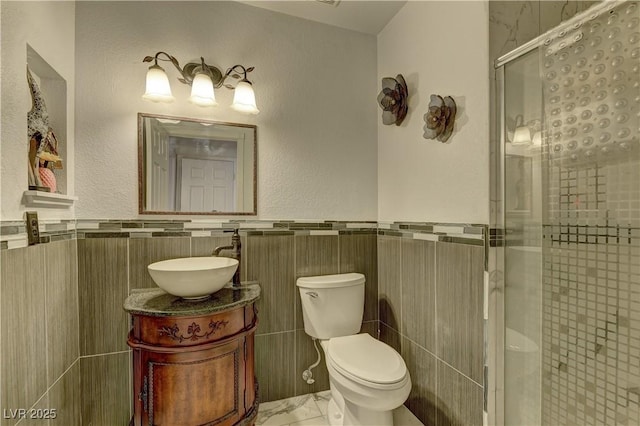 full bathroom with vanity, a stall shower, wainscoting, and toilet