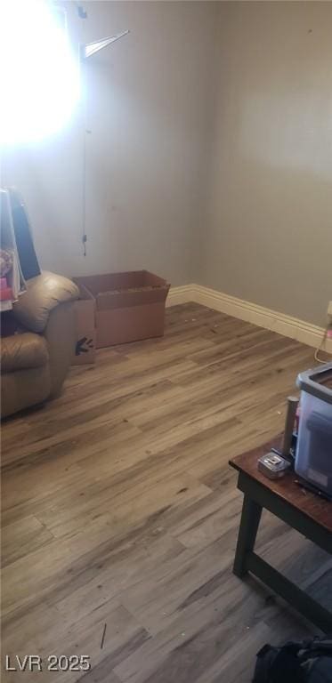 living area with baseboards and wood finished floors