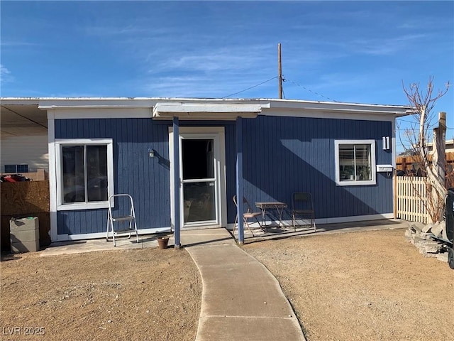 view of front of property with a patio and fence