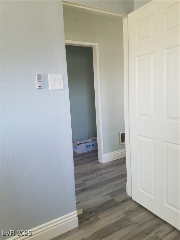 hallway with baseboards and wood finished floors