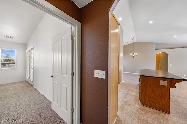 corridor featuring visible vents, recessed lighting, arched walkways, lofted ceiling, and light colored carpet