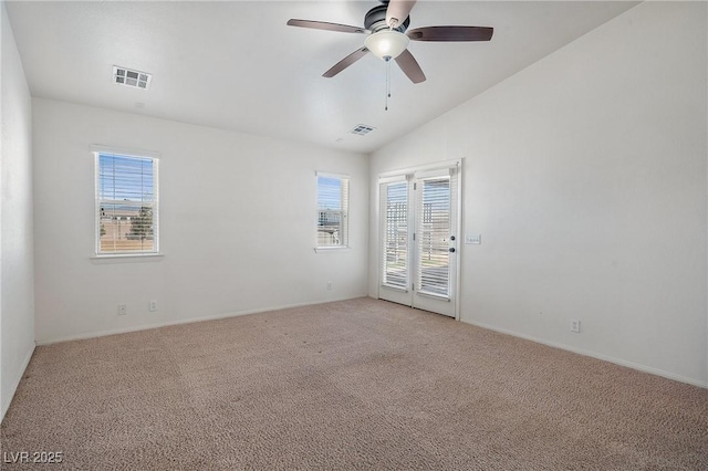 empty room with visible vents, light colored carpet, a ceiling fan, and vaulted ceiling