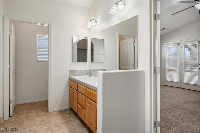 full bath with visible vents, a sink, double vanity, lofted ceiling, and ceiling fan