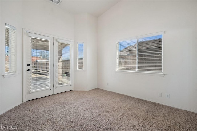 spare room featuring visible vents and carpet flooring