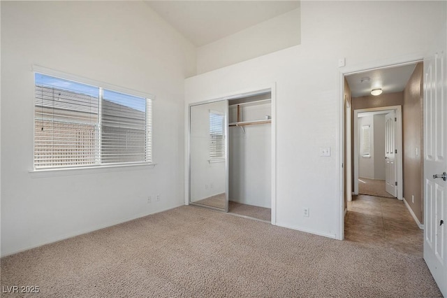 unfurnished bedroom featuring a closet, carpet floors, and vaulted ceiling