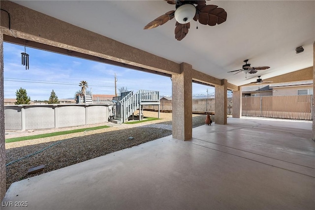 view of patio / terrace with stairway, a ceiling fan, and fence