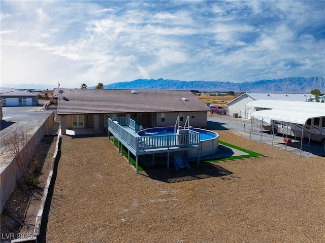 rear view of property featuring a fenced in pool, a mountain view, and a fenced backyard