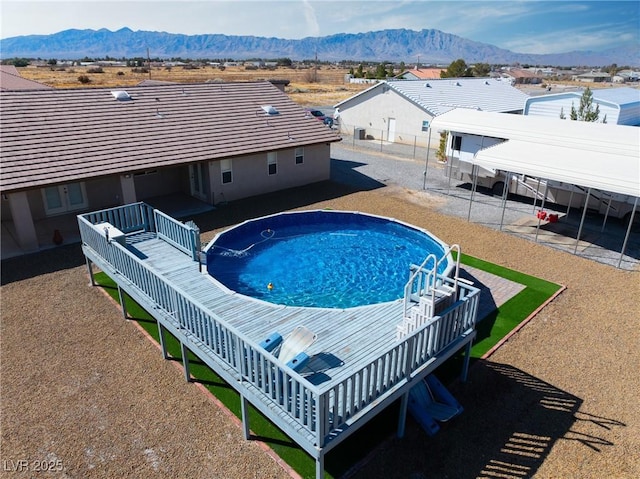 view of swimming pool featuring a mountain view, a patio, and fence