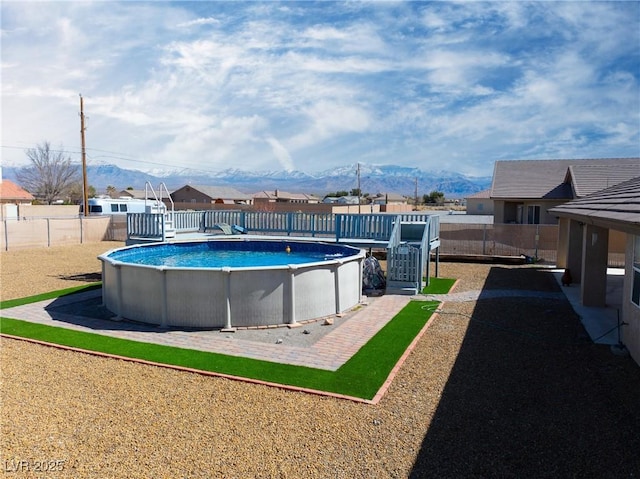 view of swimming pool with a fenced in pool, a fenced backyard, and a mountain view