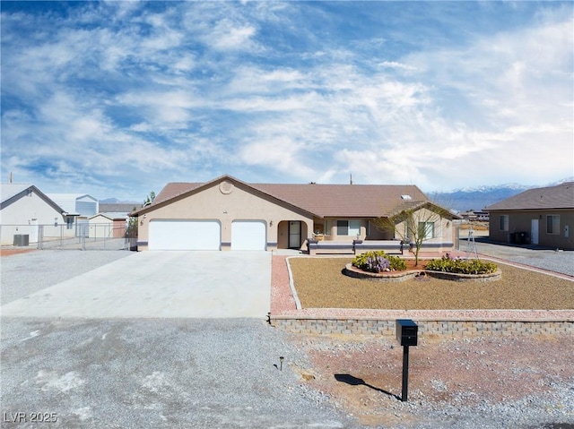 view of front of house featuring stucco siding, driveway, fence, cooling unit, and a garage