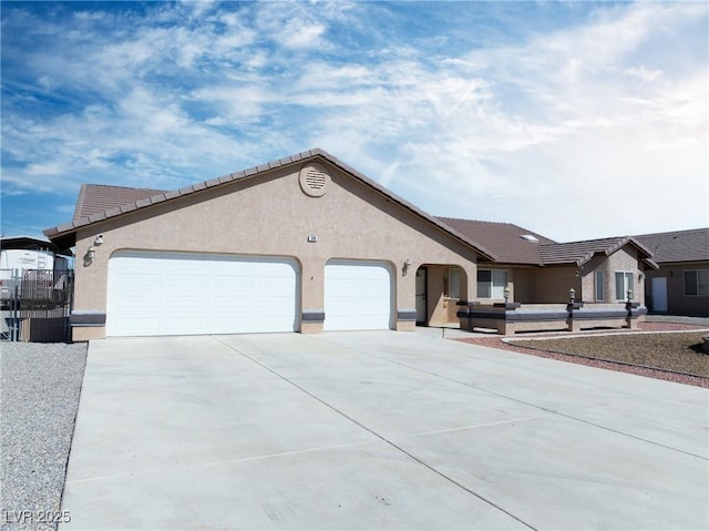 view of front of home featuring stucco siding, concrete driveway, and an attached garage