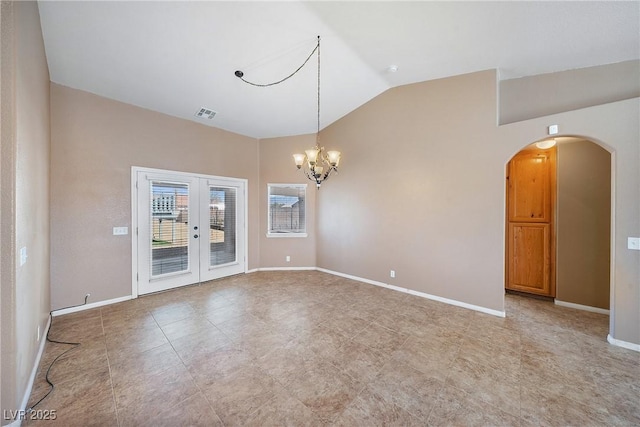 spare room with visible vents, french doors, arched walkways, baseboards, and vaulted ceiling