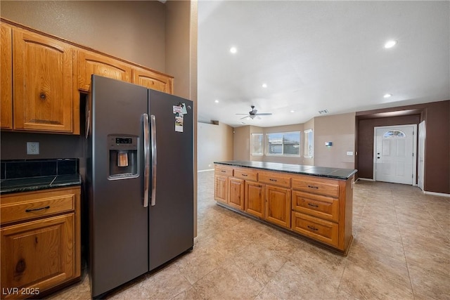 kitchen featuring a ceiling fan, dark countertops, stainless steel fridge with ice dispenser, and brown cabinets