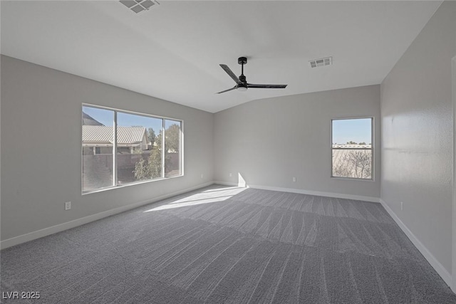 carpeted spare room with a wealth of natural light, visible vents, and baseboards