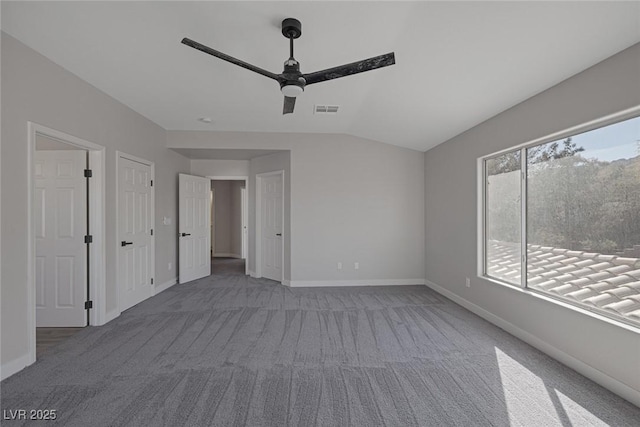 interior space featuring visible vents, baseboards, lofted ceiling, and carpet floors