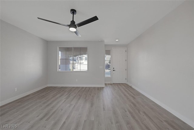 unfurnished living room with a ceiling fan, light wood-style floors, and baseboards