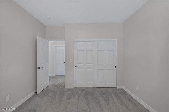 unfurnished bedroom featuring carpet flooring, baseboards, and a closet