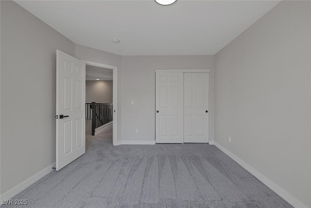 unfurnished bedroom featuring a closet, baseboards, and carpet floors