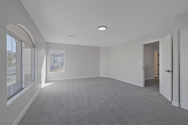 empty room featuring baseboards and carpet